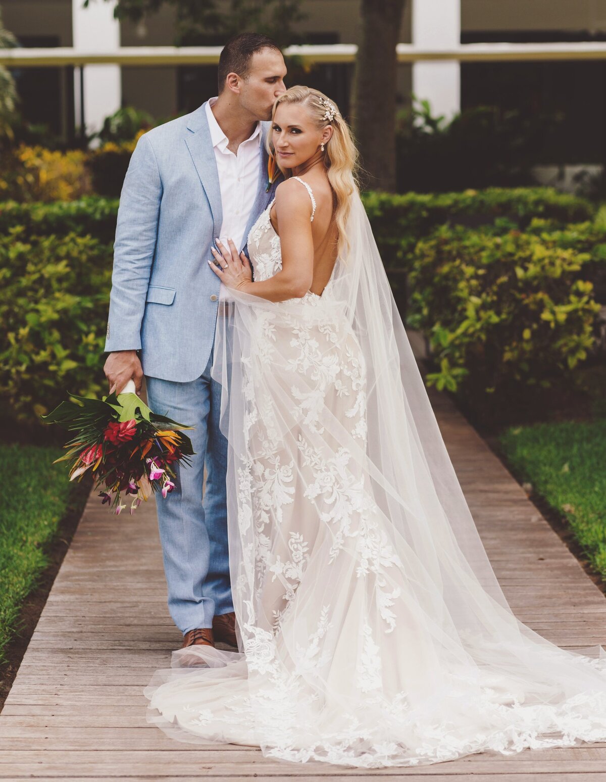 Bride cuddling into groom before wedding in Cancun