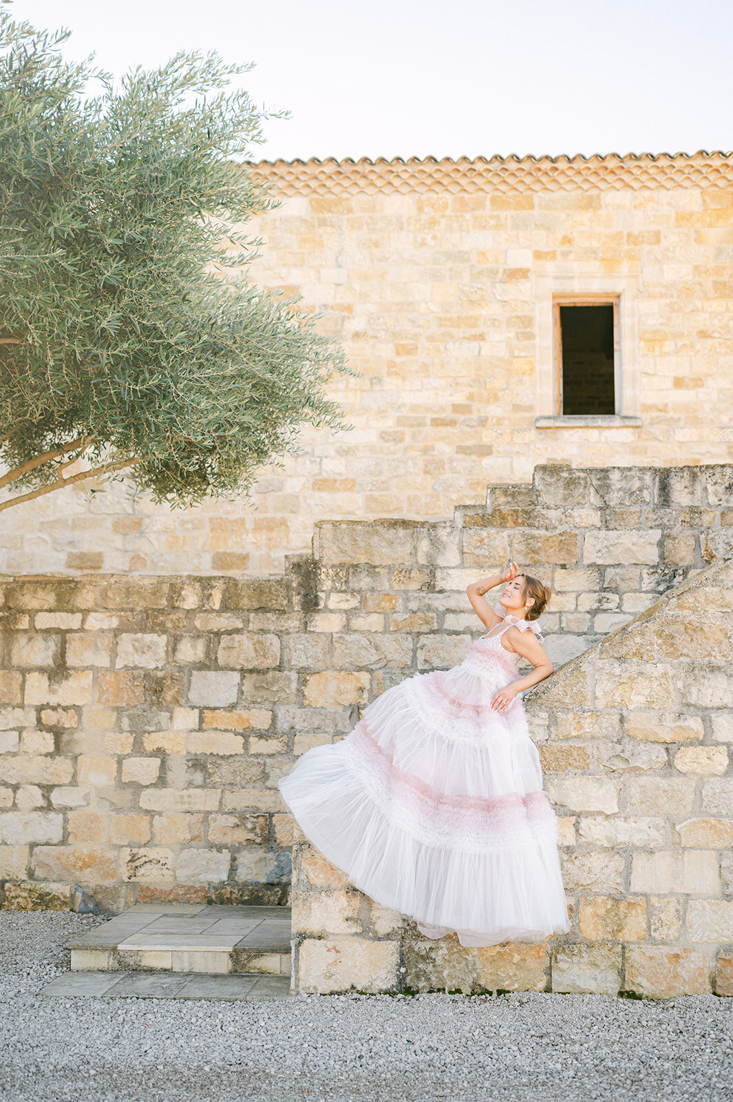 Bride sitting on ledge at Sunstone Villa wedding venue.