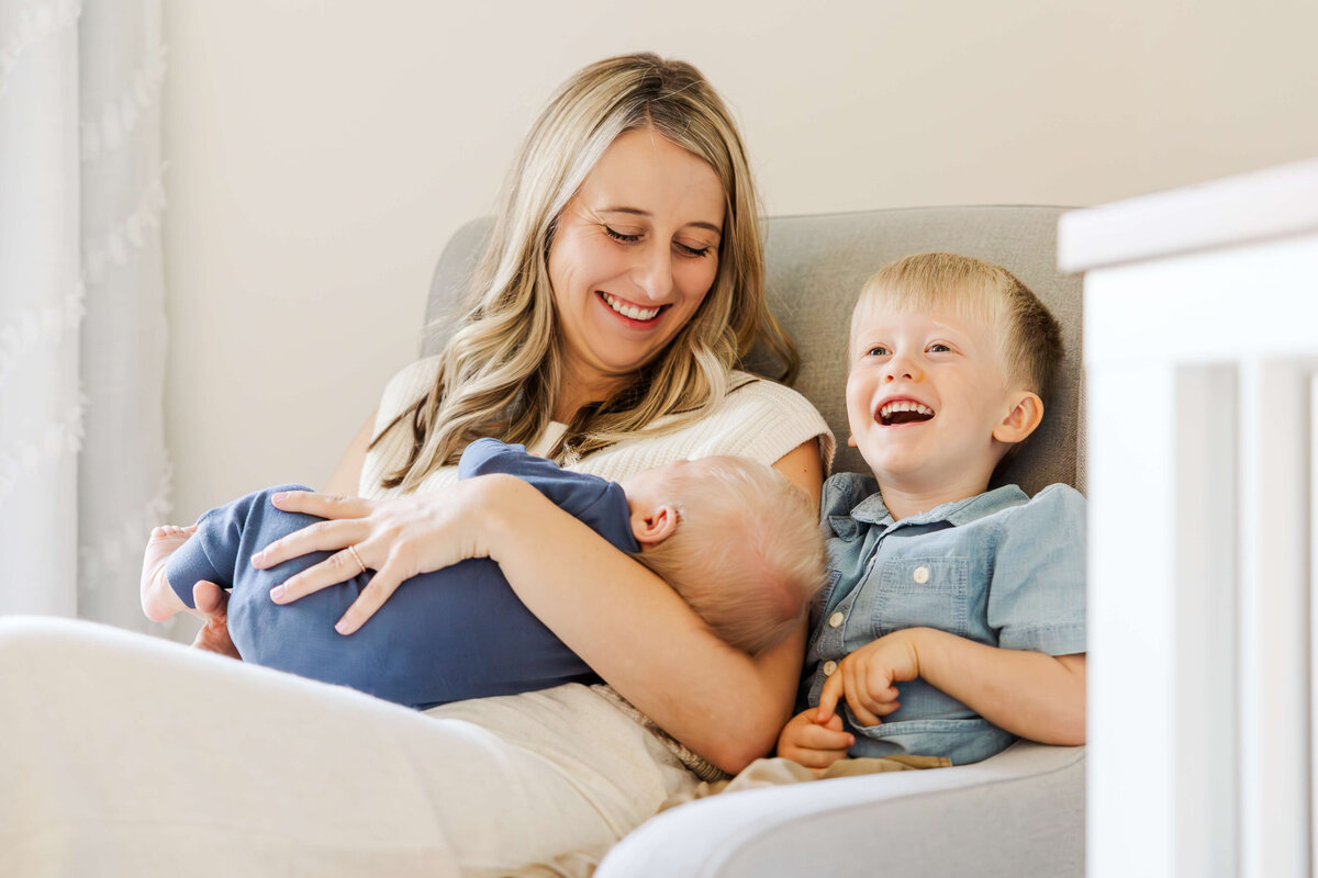 mom-with-newborn-and-brother-sitting-in-chair-northville-mi-14