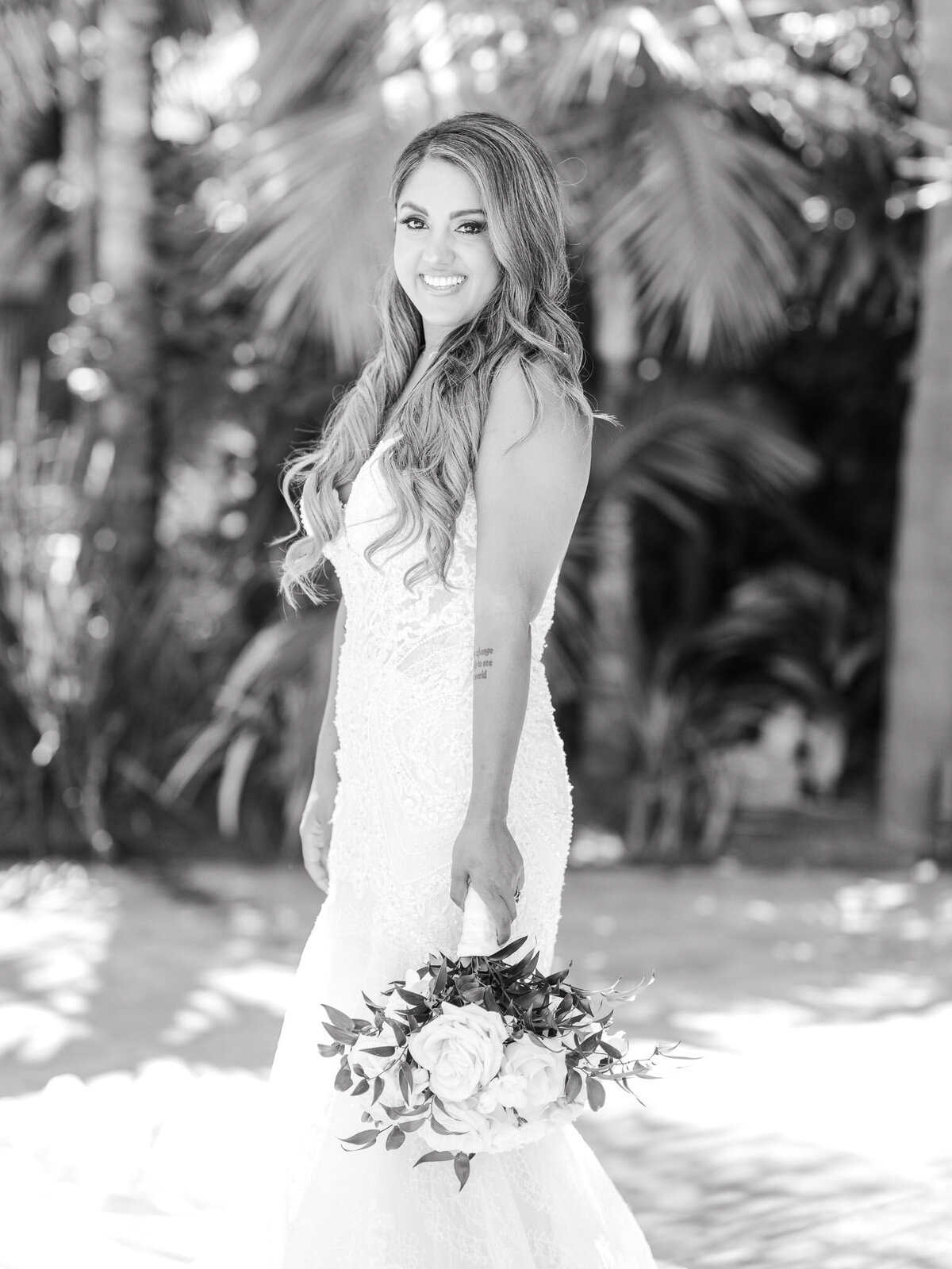 A timeless black-and-white portrait of the bride standing in a lush garden, holding her bouquet at the Ritz-Carlton Laguna Niguel