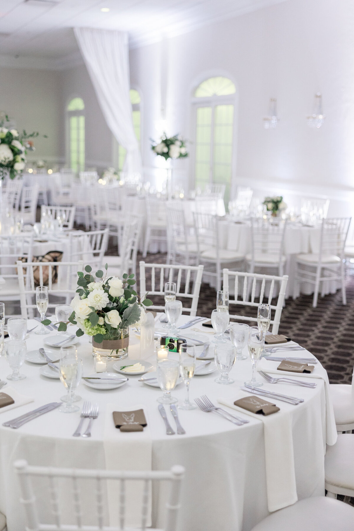 An all white wedding reception with tiny pops of brown