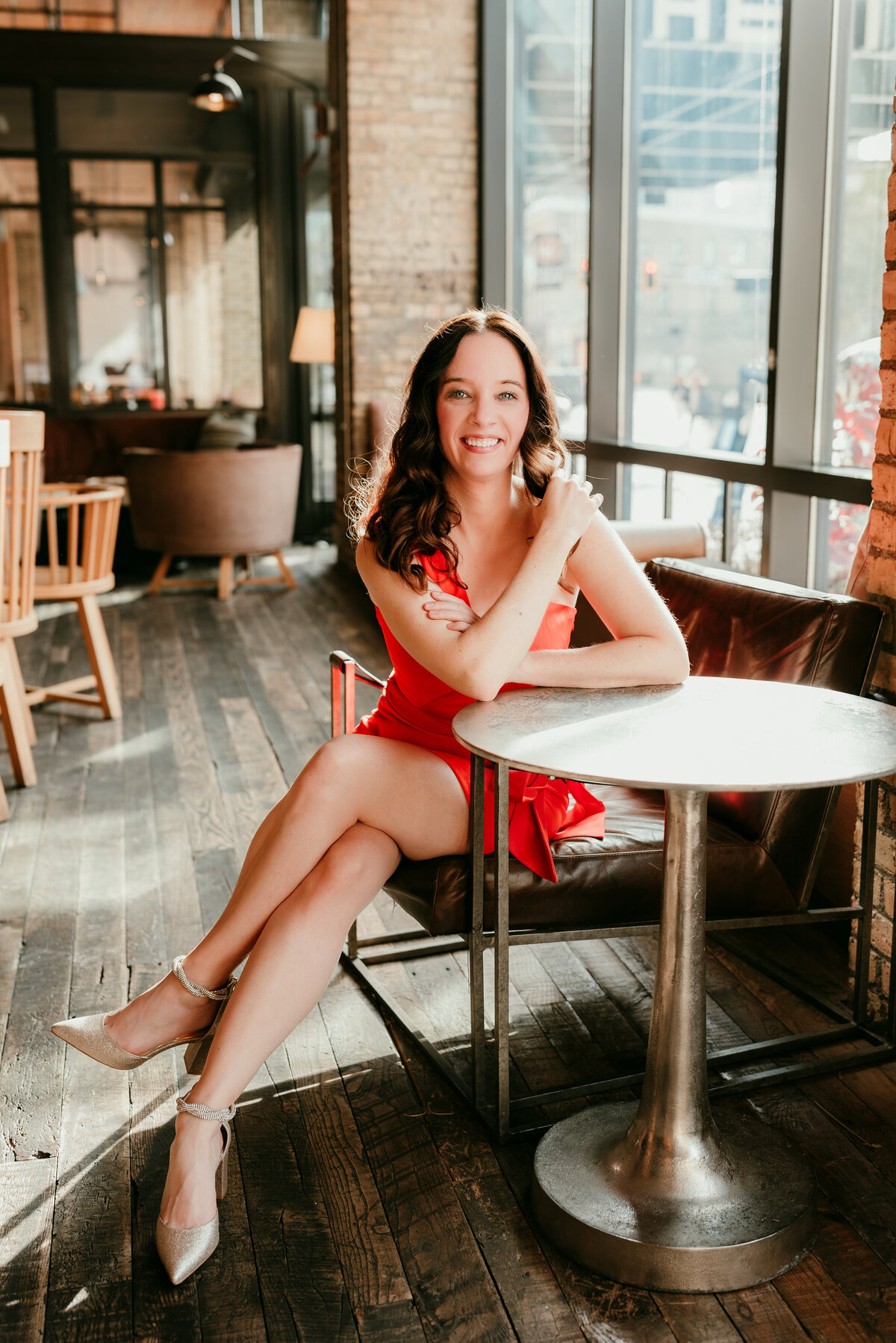 A sophisticated online dating photo of a woman sitting in the stylish lounge of the Hewing Hotel in Minneapolis.