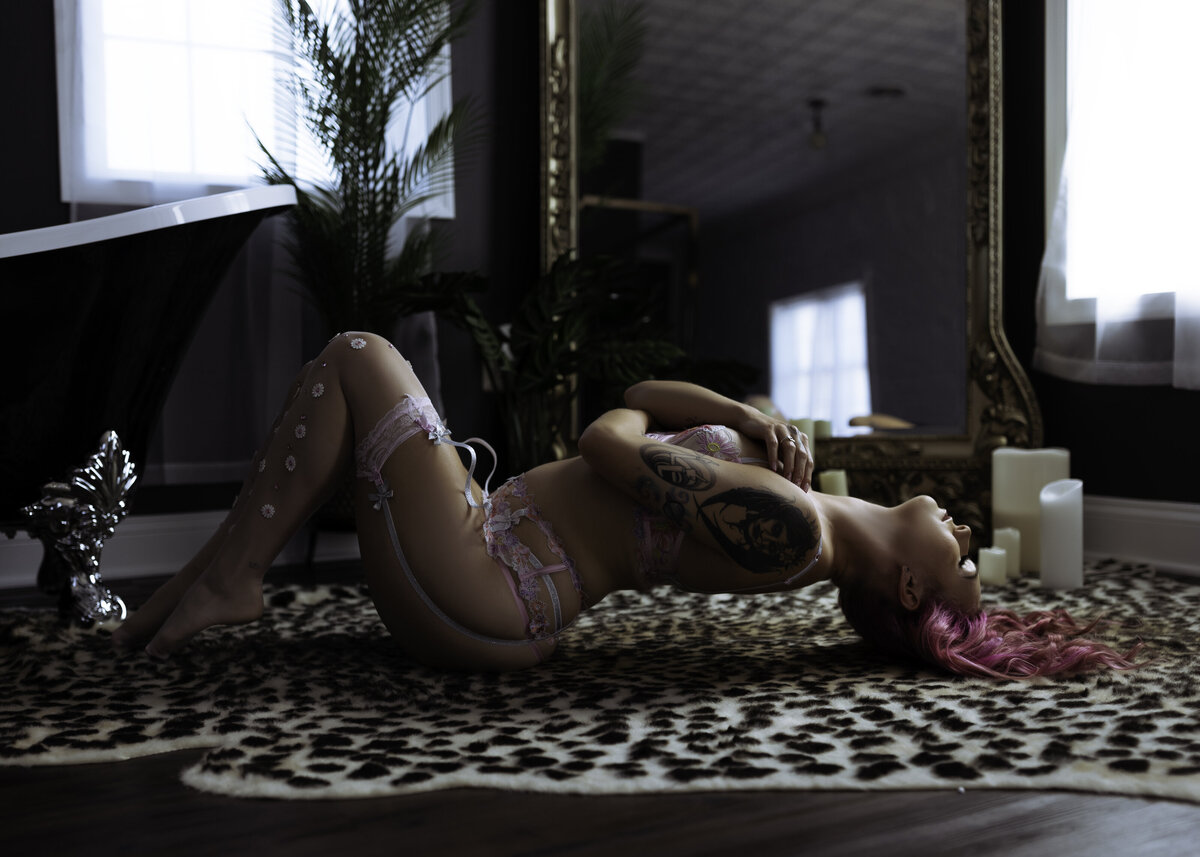 Boudoir Photographer, a woman wears lingerie and arches back  while laying on the ground
