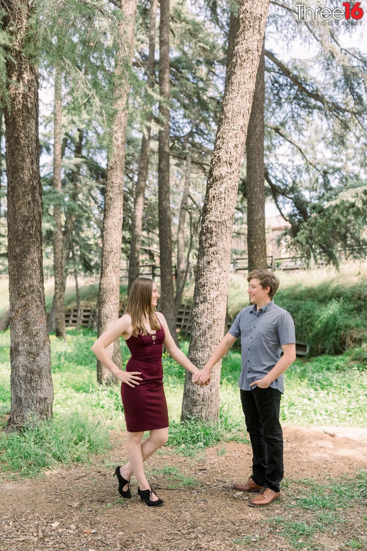 Engaged couple gaze at each other while hands during photo session