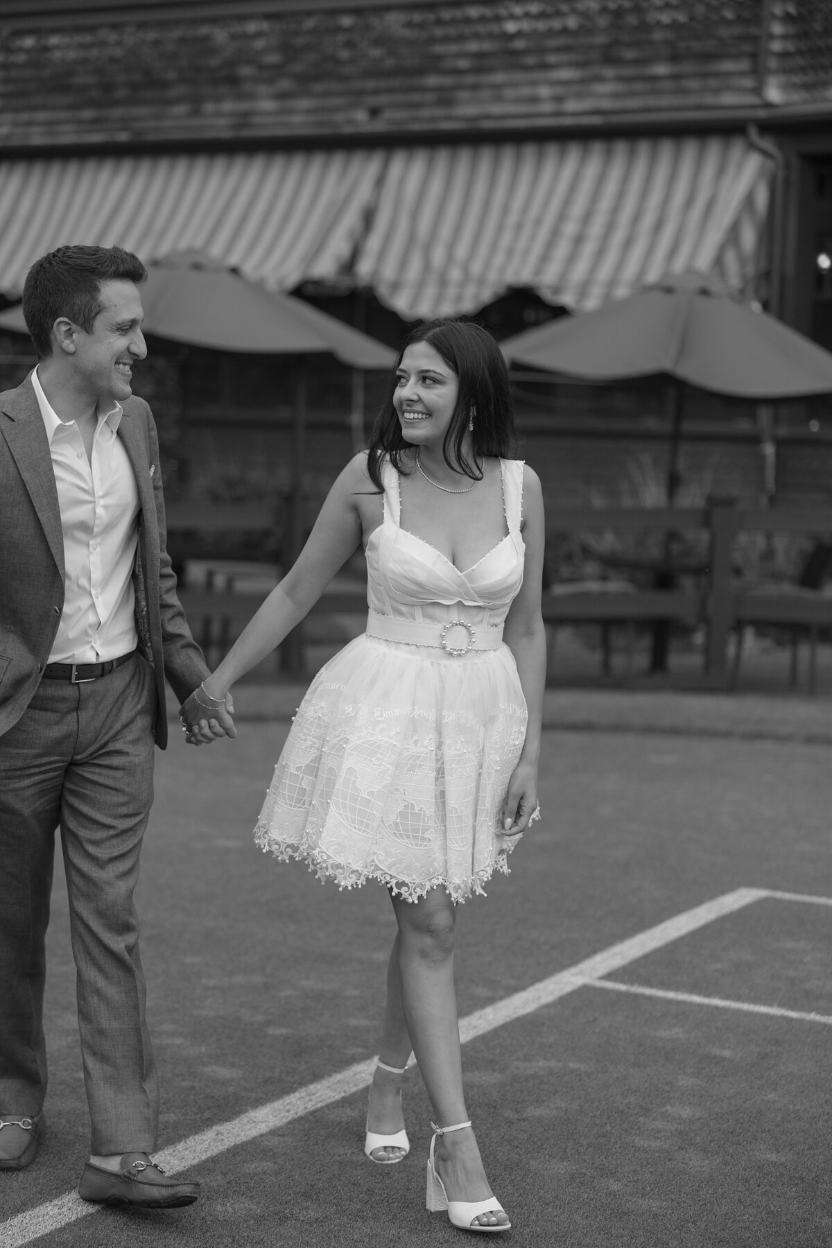 Couple walk hand in hand across the lawn at the Tennis Hall of Fame during welcome party. Deborah Zoe Photography.