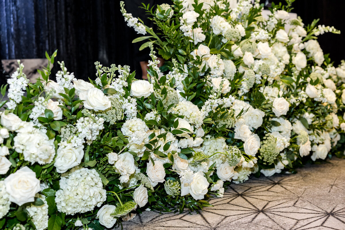 lush white floral stage facade spanning 16 feet, elegantly lining the front of the stage at the African American Real Estate Professional gala