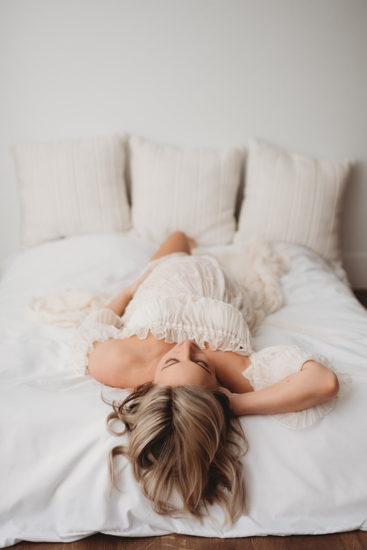 pregnant woman lying on her back on studio bed