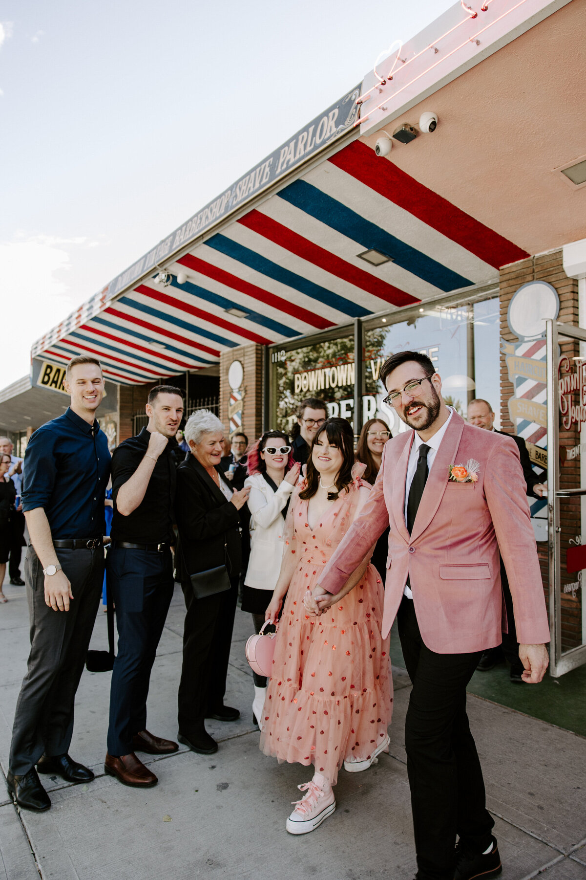A couple poses outdoors with their family on their elopement day.