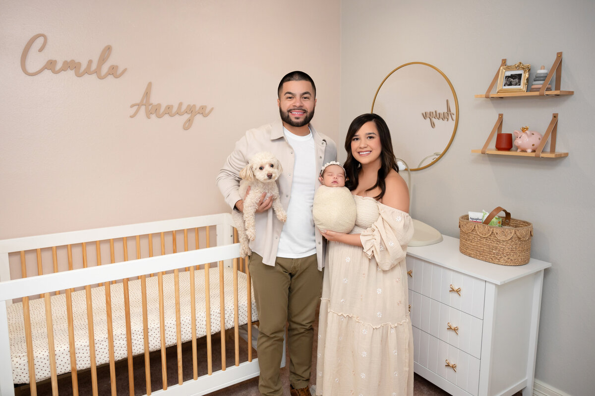Natural family portrait in Houston nursery with newborn and parents.