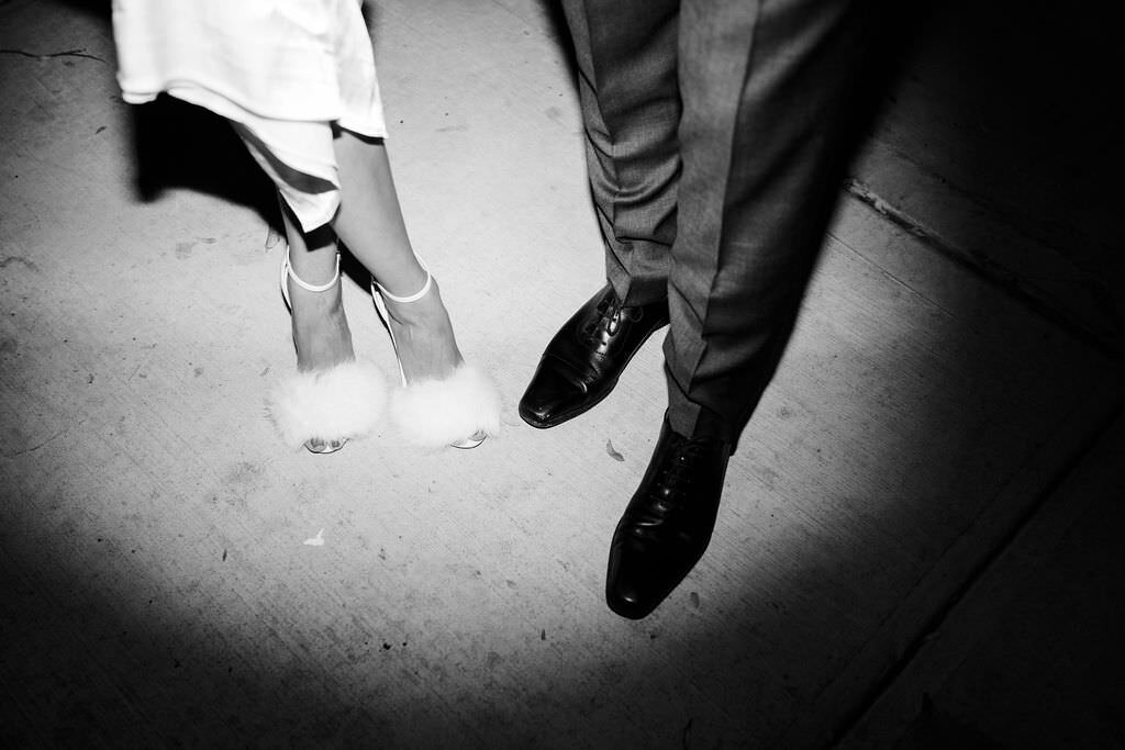 black and white photo of a spotlight on the feet of the bride and the groom