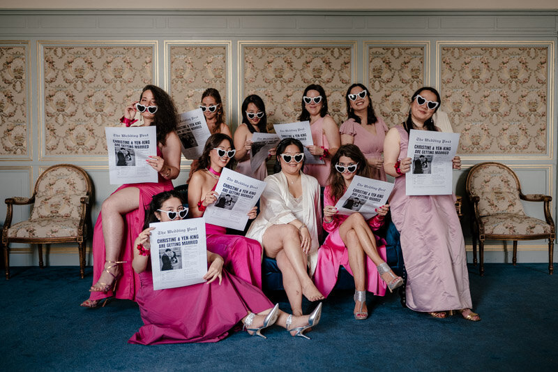 La mariée et ses demoiselles d’honneur posent en tenues roses et lunettes en cœur, façon photo de groupe style Vanity Fair, pendant les préparatifs au Château de Saint-Martin-du-Tertre.