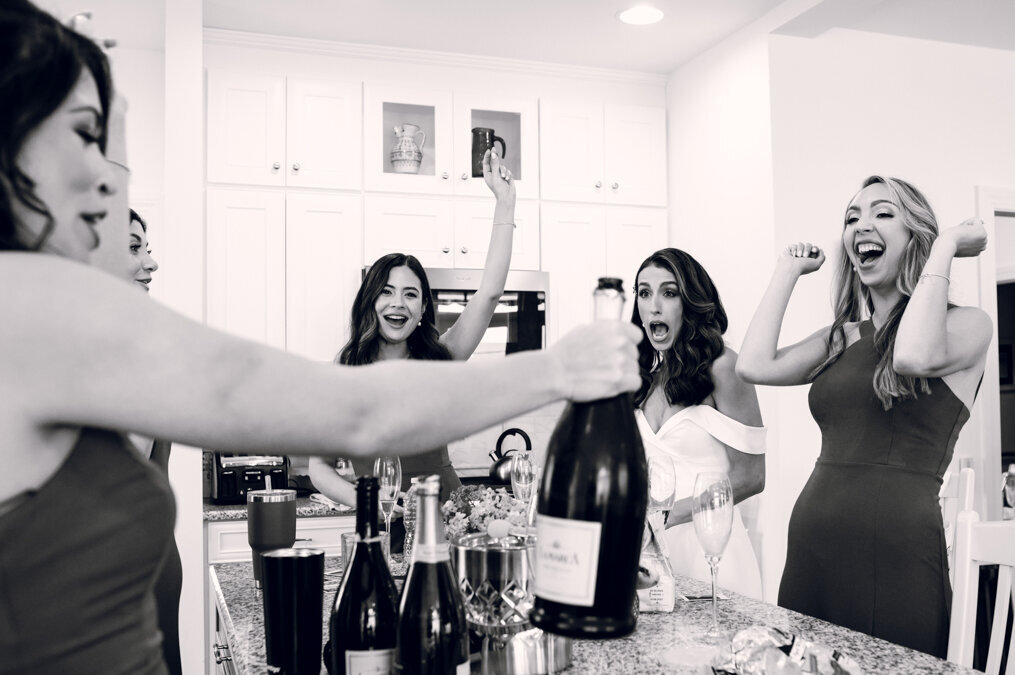 A group of bridesmaids celebrating in the kitchen.