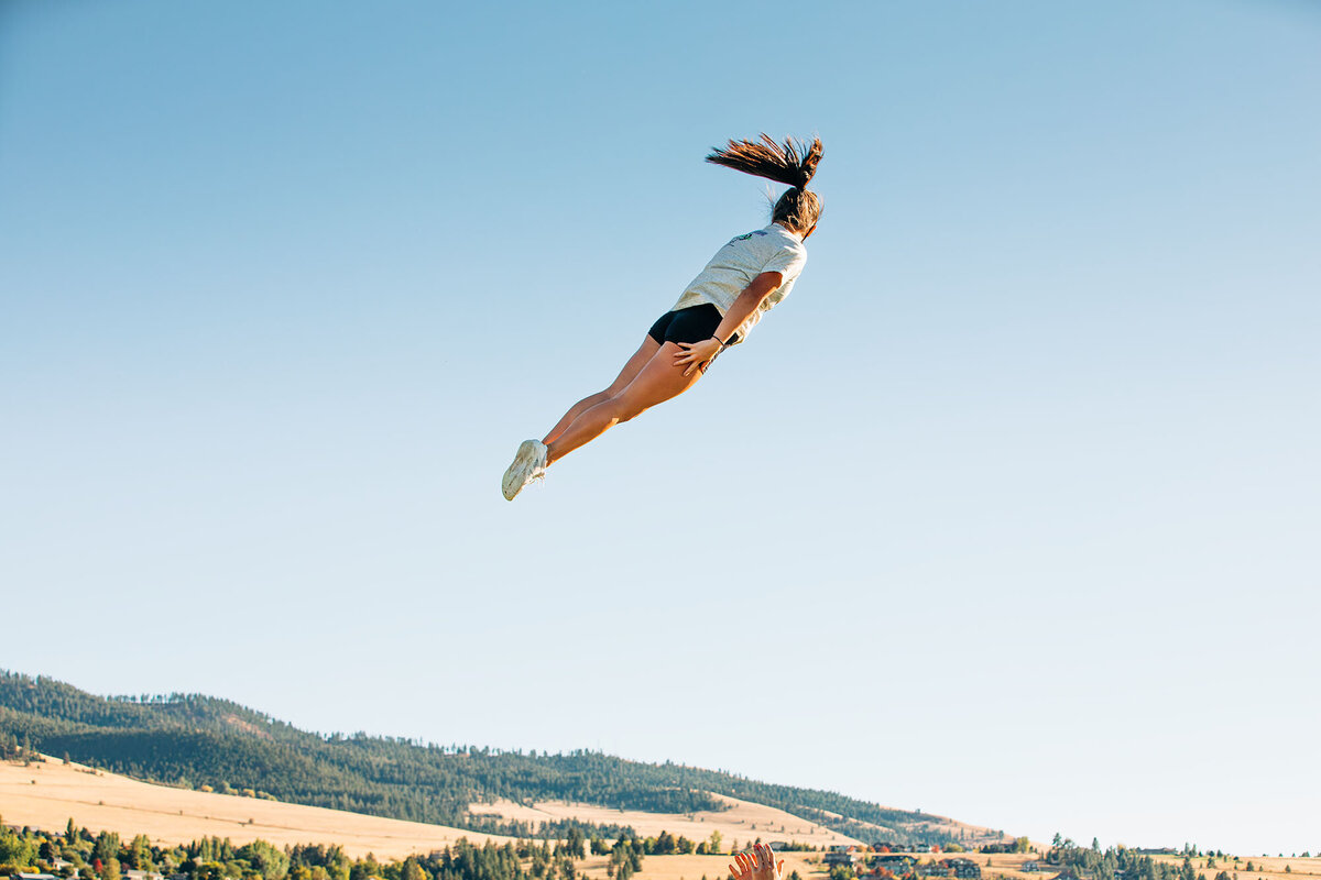 Cheerleader flying in air at cheerleading practice, Missoula, MT