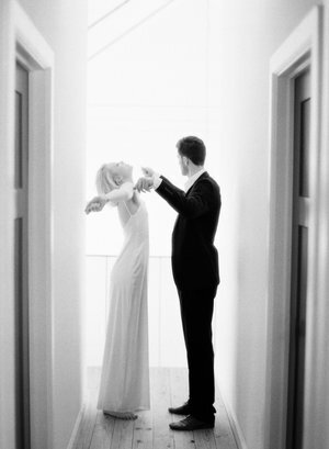 Matthew Moore - black+and+white+candid+fine+art+photograph+of+bride+in+slip+dress+stretching+arms+near+groom++in+Austin+home