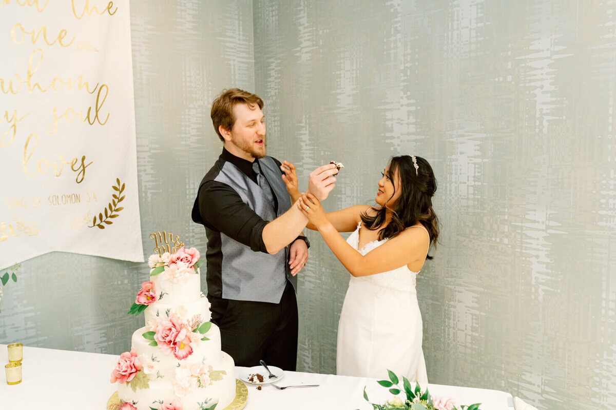 Bride and Groom feeding each other cake on their wedding day in Dayton, OH.