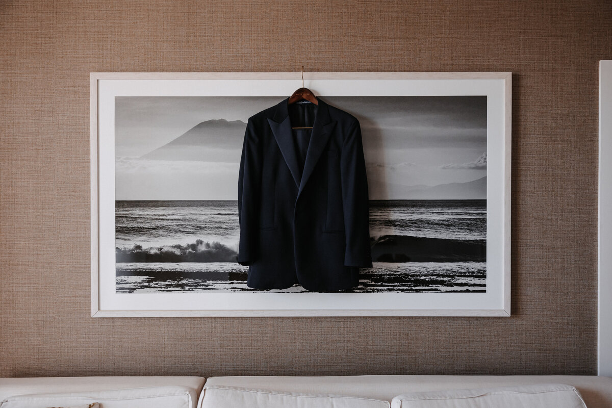 Suit coat jacket hanging from a large picture frame in a hotel room