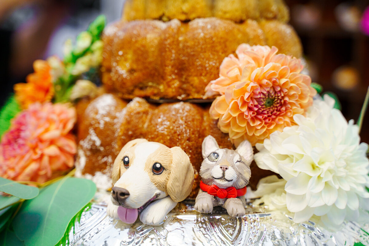 Miniature dog and cat figurines placed at the bottom of a colorful wedding cake at The Revery (North 4th Corridor) in Columbus, Ohio.