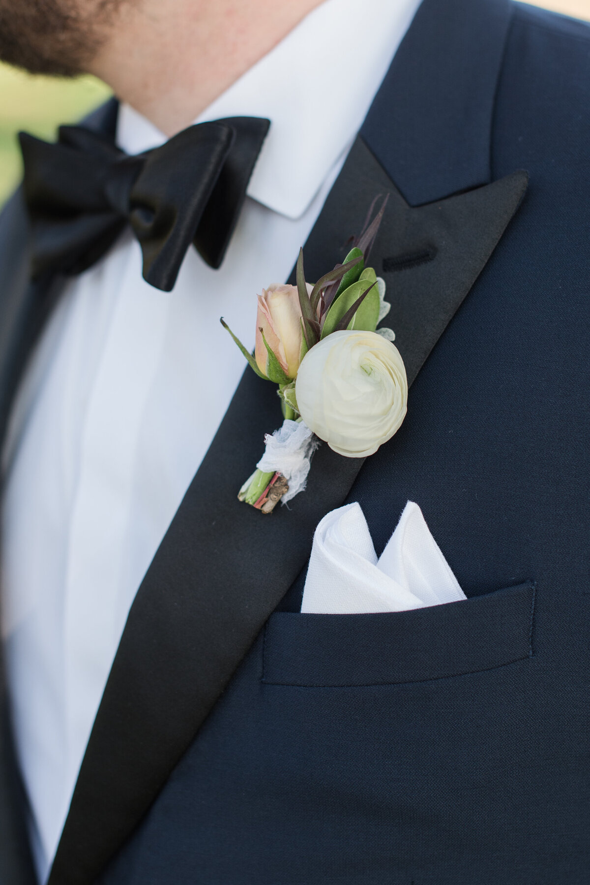 goom bouttoniere white flower on black tuxedo
