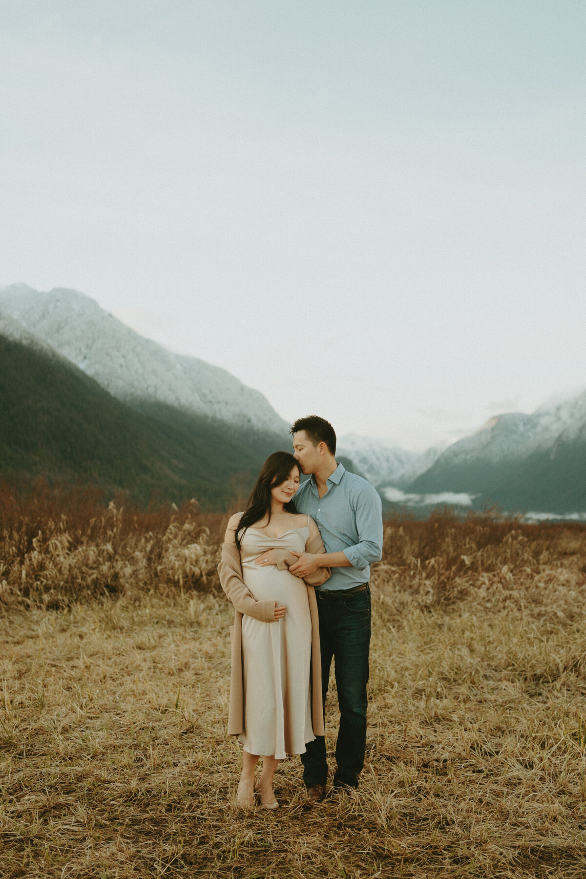 maternity photo  husband holding wife in the mountains