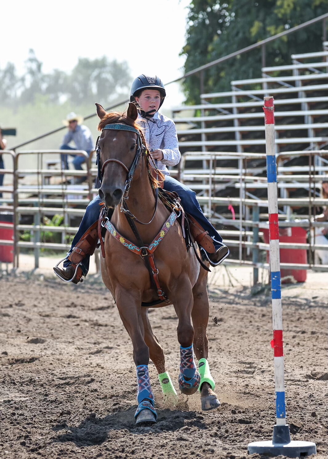 A Livermore, CA Rodeo Princess young rider races through poles a the Livermore Rodeo