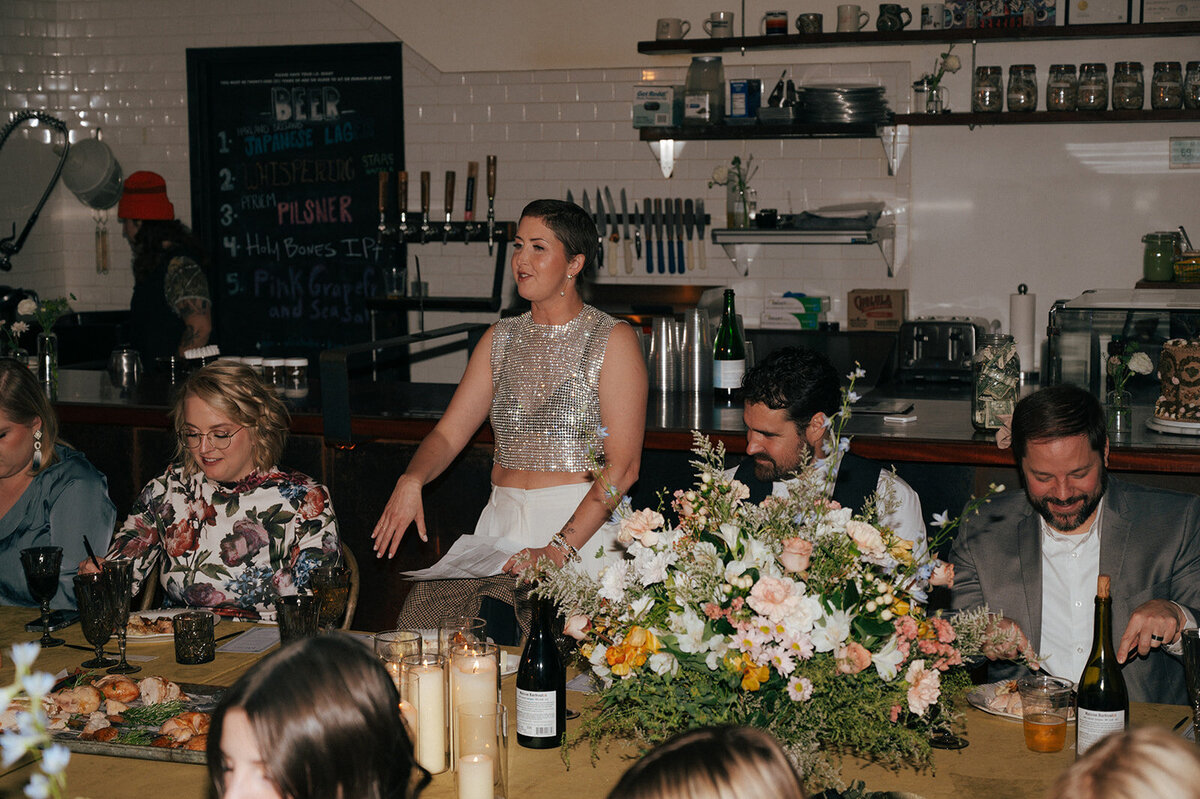A woman giving a speech at Push and Pour at her intimate vow renewal planned by Perfect Thirds and Co. 