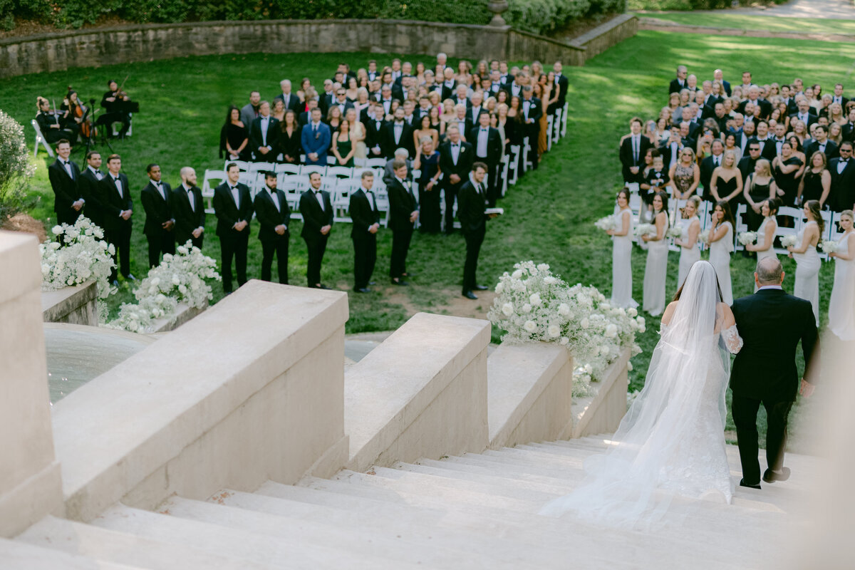 bride escorted down stairs at The Swan House wedding