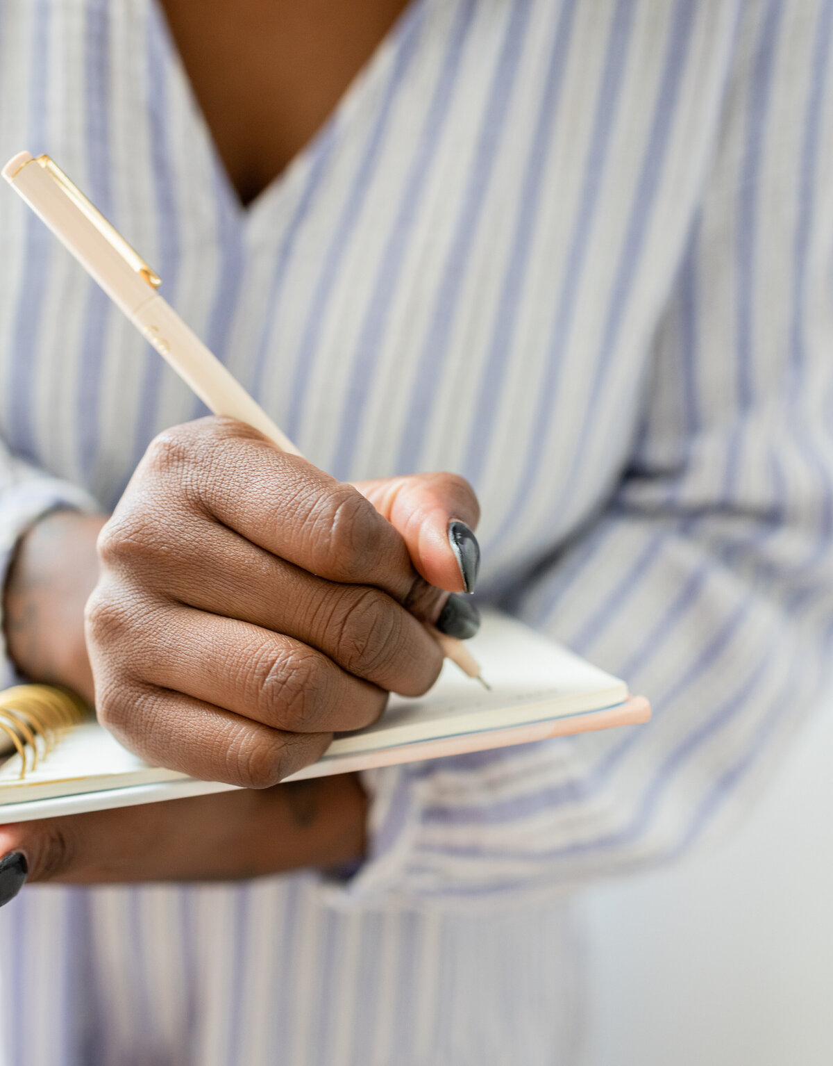 close up of a woman writing in a notebook