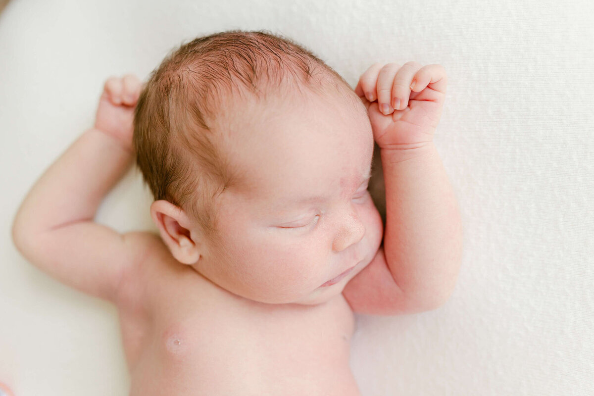 Soft natural light portrait by a newborn photographer Bay Area, baby sleeping on bed.