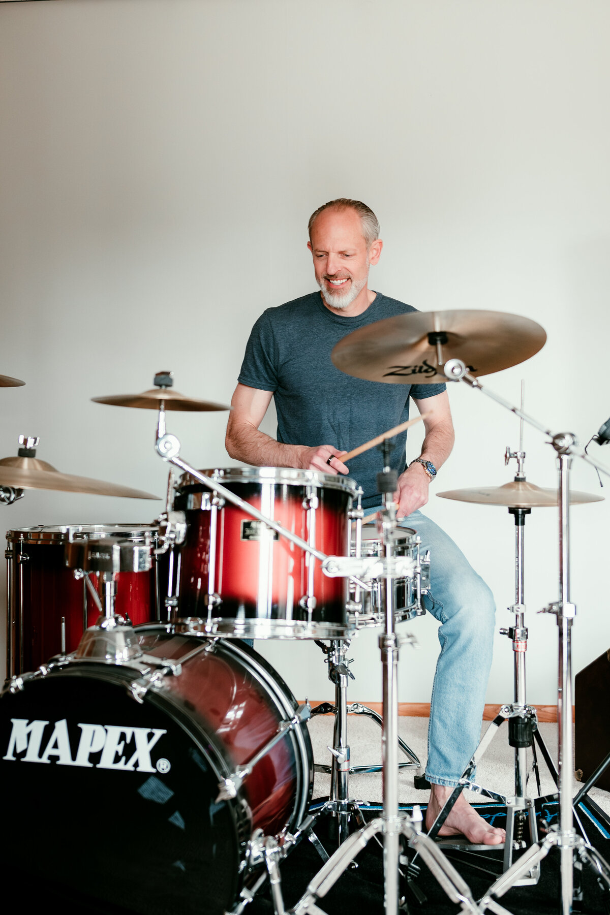 Stylish older man playing drums in his home studio for lifestyle online dating photo showcasing personality and creativity