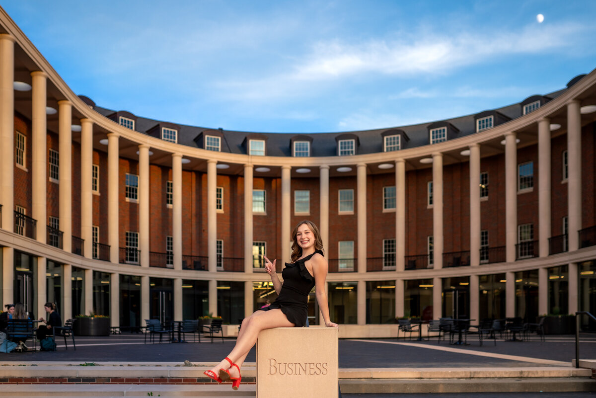 A business school graduation poses in front of her school at Oklahoma State Univeristy.
