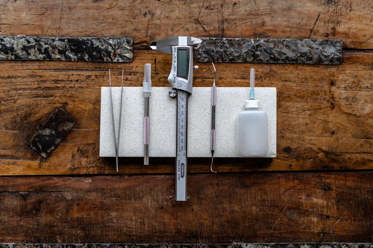 A curated flatlay featuring the artist’s tools and materials used to create luxury acrylic signage. The image offers a behind-the-scenes look at the hands-on craftsmanship that defines her brand.