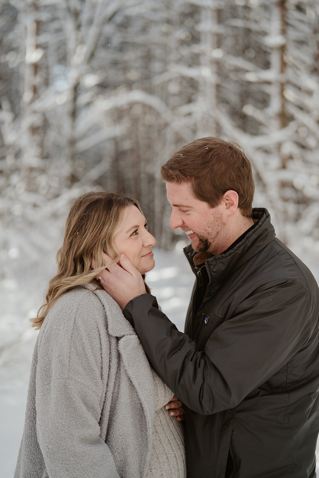 A couple standing together in the snowy pines at Al Sabo in the Winter 