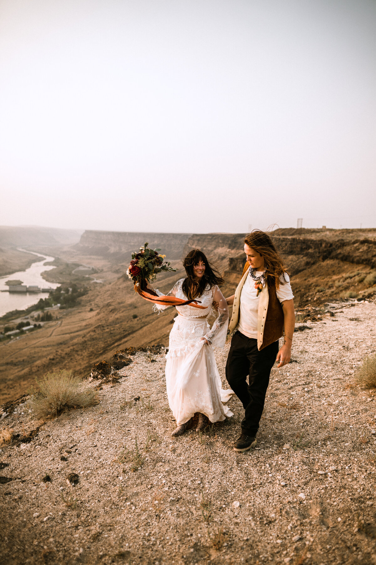 lesbian brides walking along the rim of the snake river canyon