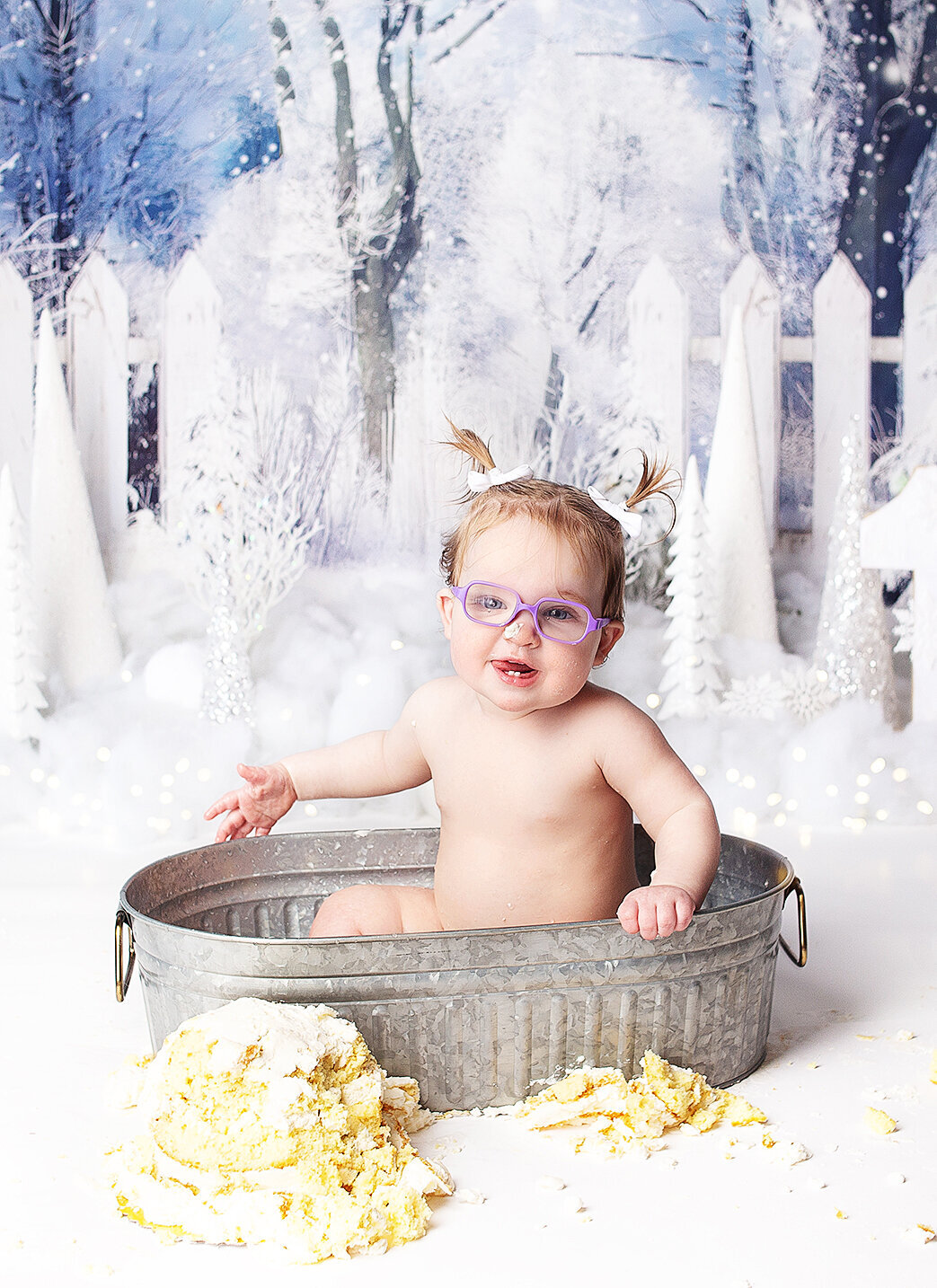 Baby girl sitting in tub with cake during first birthday cake smash photoshoot with Franklin Tennessee photographer in Franklin tennessee photography studio