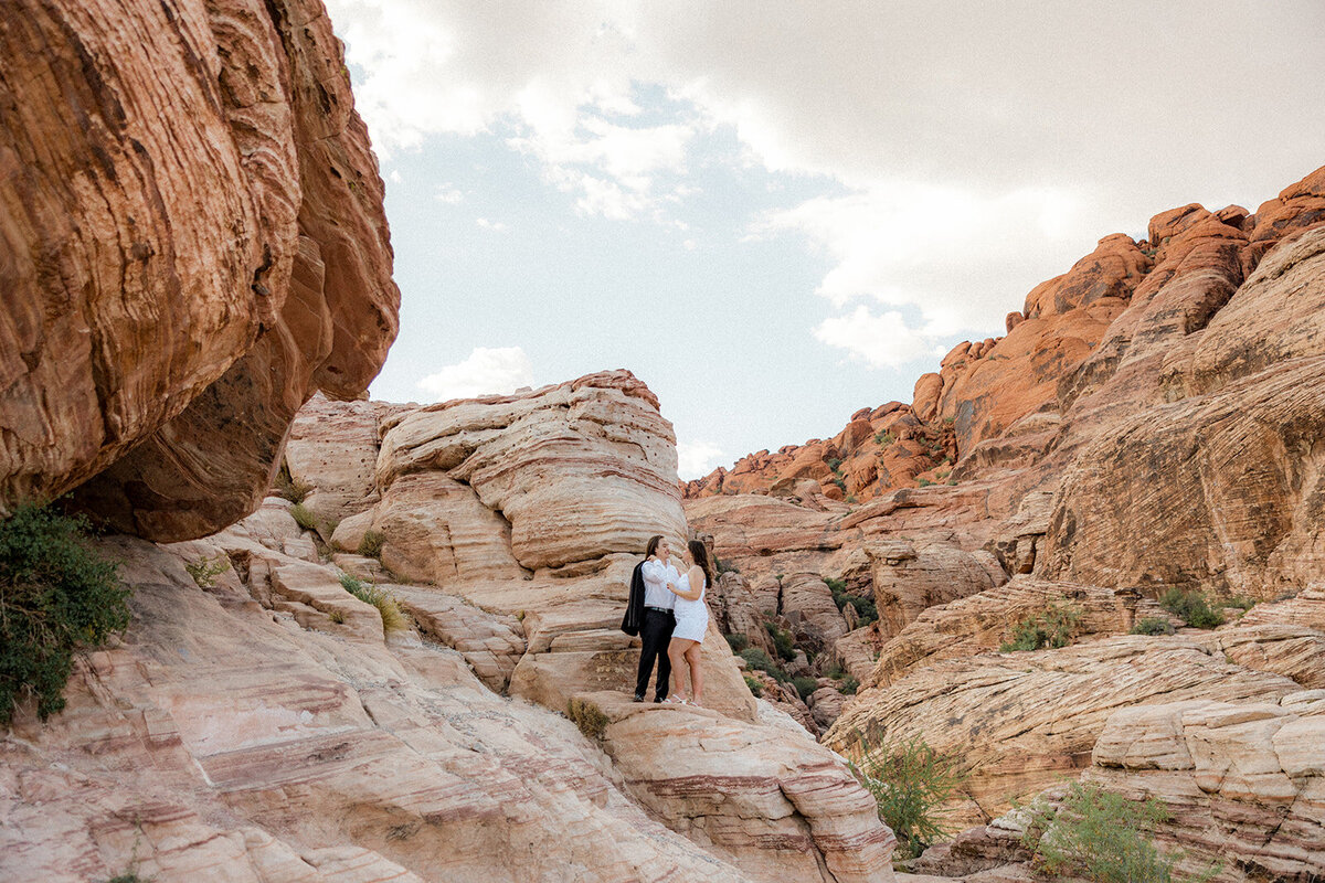 Landscape image of engaged couple on a rock at the Red Rock Canyon