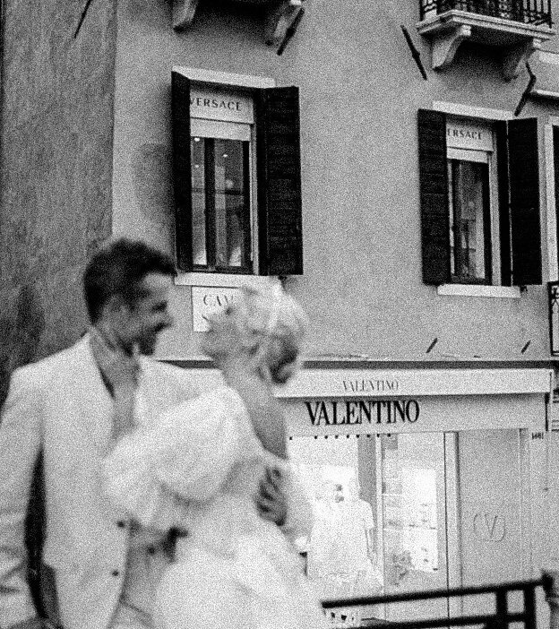 The couple embracing and laughing in the historic streets of Venice, a timeless capture by Christine Grace Photography.