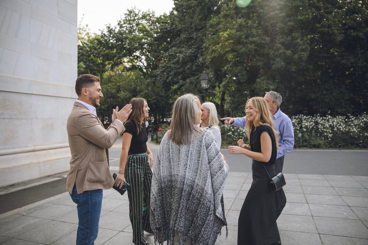 Group cheering and congratulating the couple in the park.