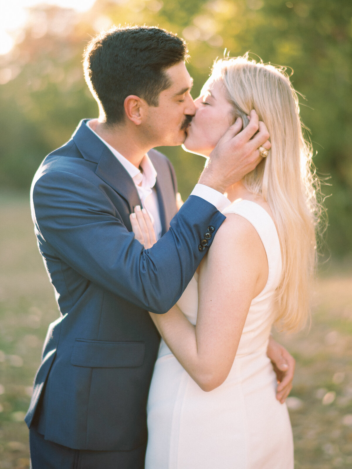 engaged couple candid kissing in love at golden hour happy