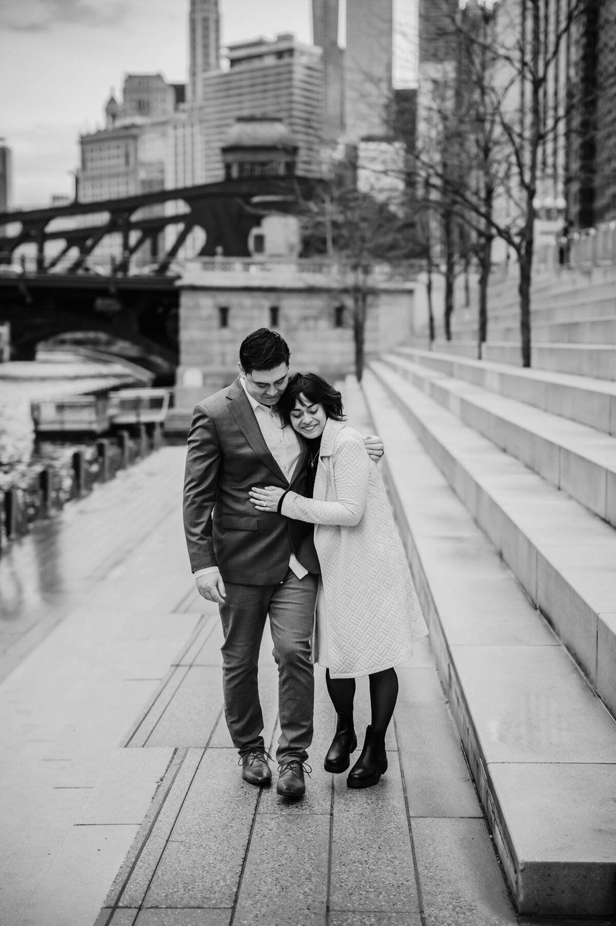 A couple embrace while walking in the Chicago Riverwalk.