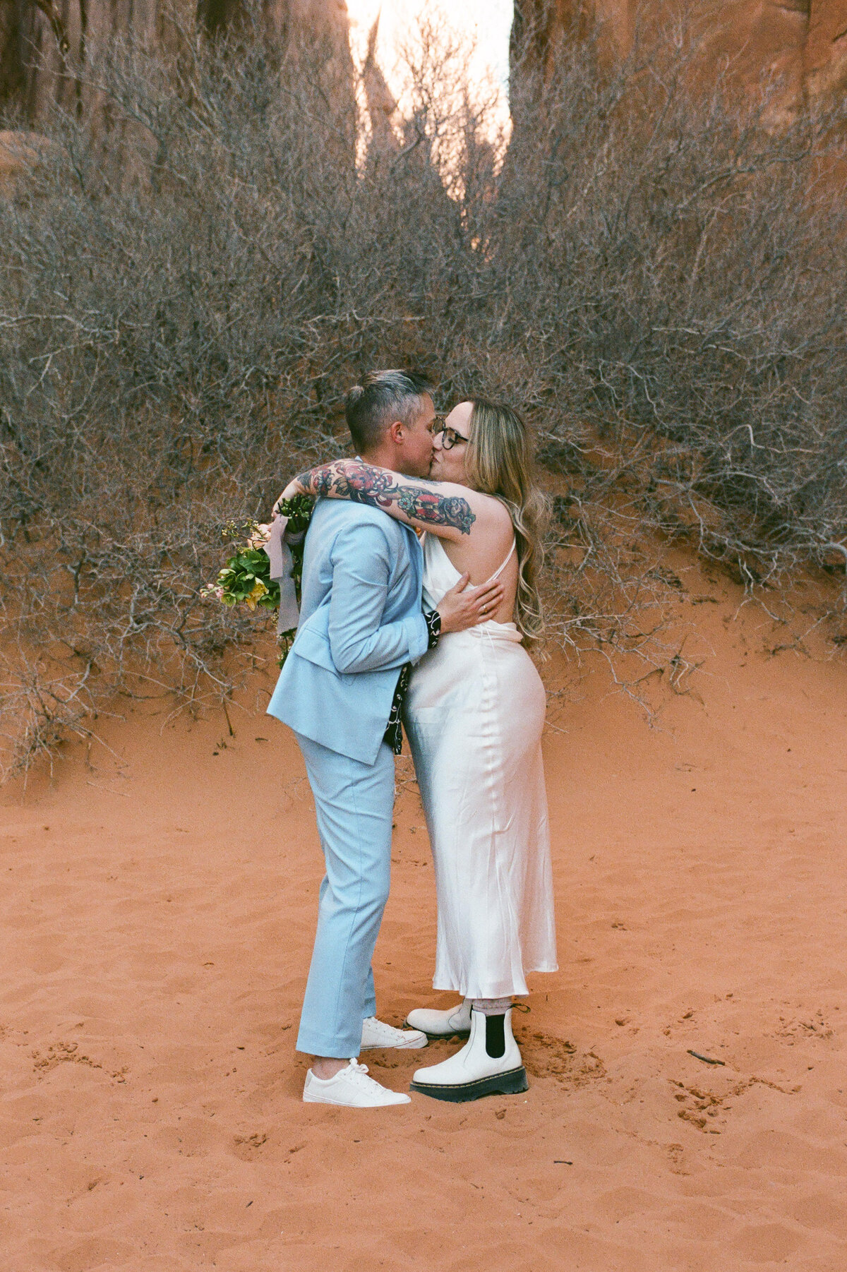 A couple kisses in the sand