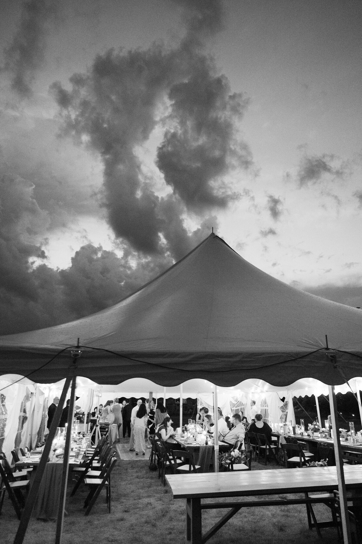 A wedding reception under a tent in a field