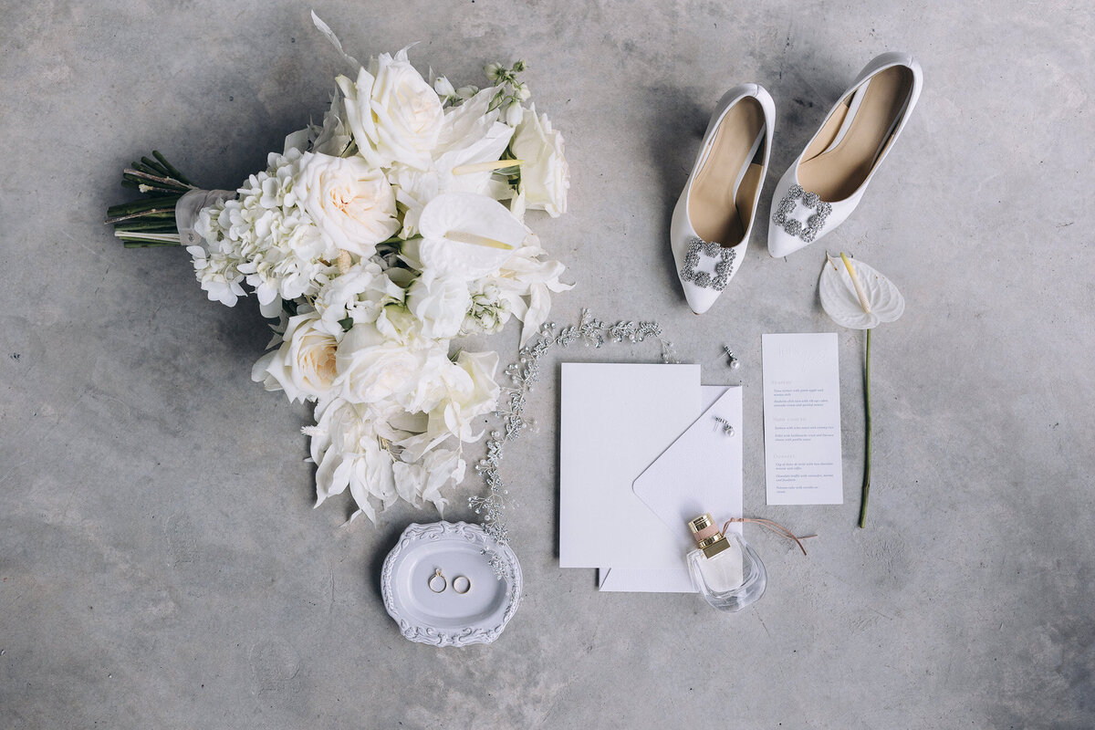 All-white wedding invitation suite styled with soft textures for White Whisper wedding in Tuscany