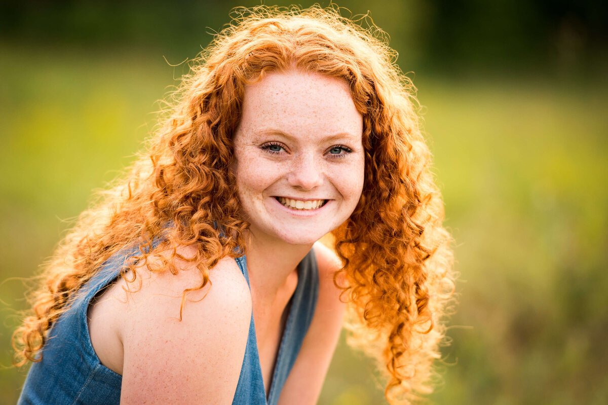family photos in Ottawa showing a closeup of a redhead teen in a grassy field
