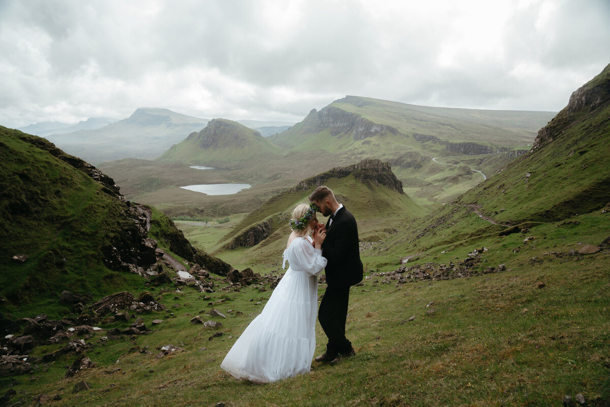 Wedding couple doing one of the best eloping ideas: sharing an intimate moment in the Scottish mountains 