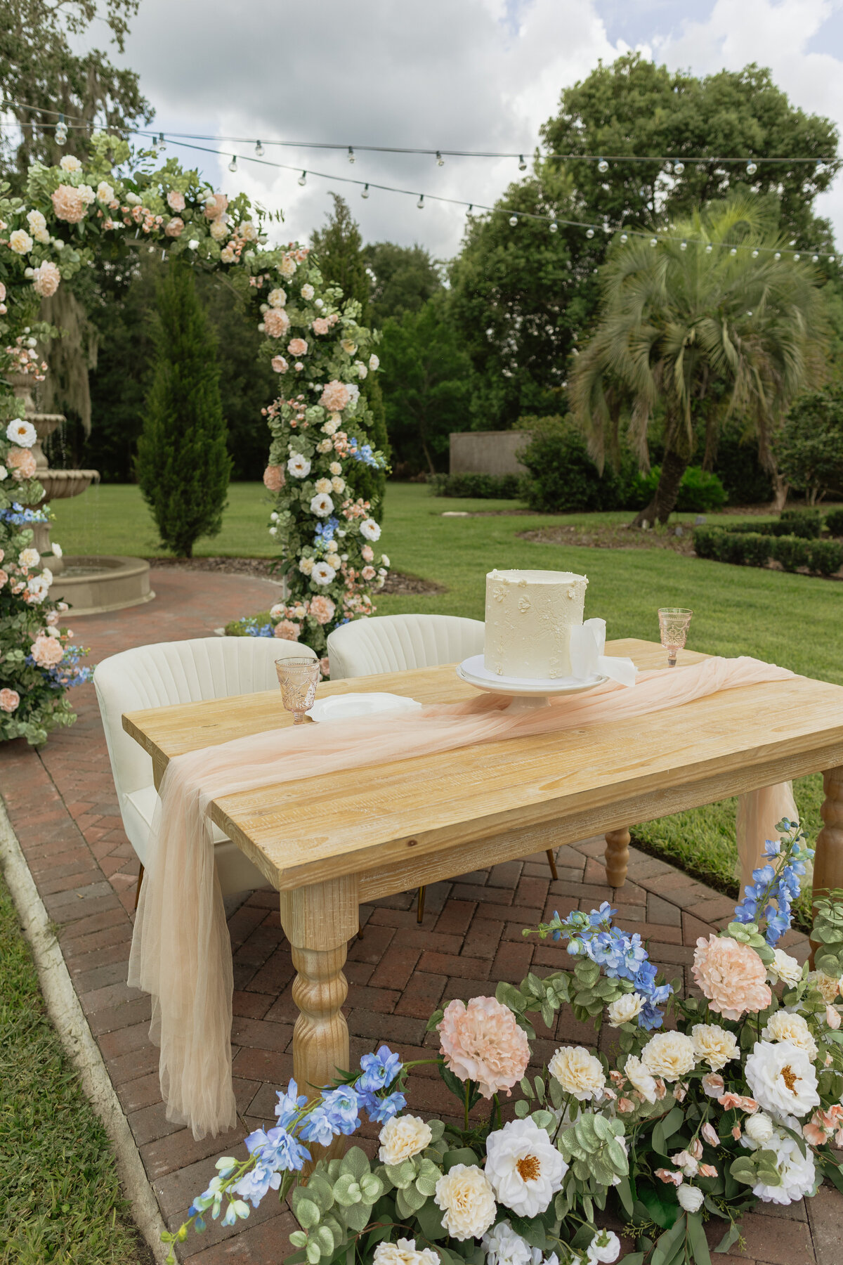 Intimate Florida wedding ceremony in the backyard of The Palm Mansion with soft florals and palm tree views