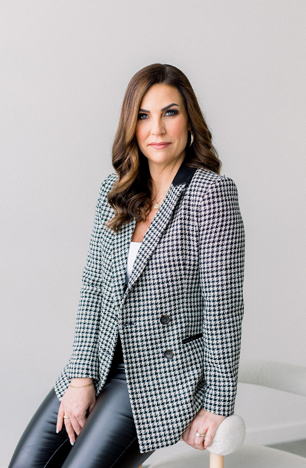Brand headshot of a brunette woman with checkered blazer