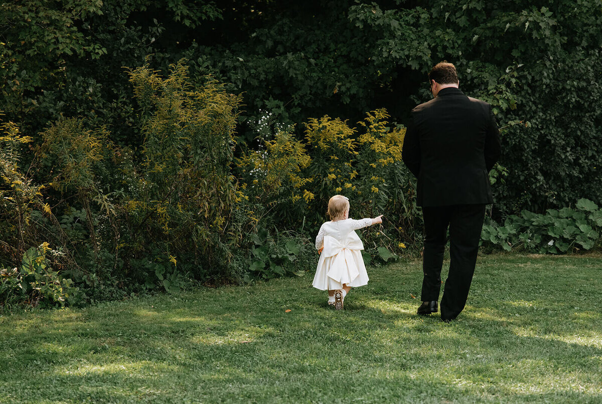 Little-girl-walking-with-man-at-wedding