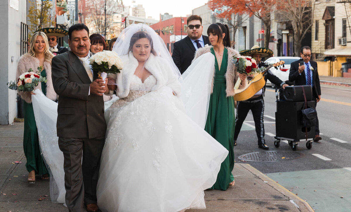 Mexican bride walking with her father towards the church in Brooklyn streets.