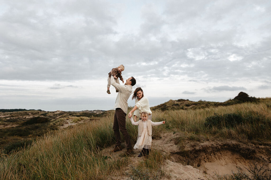 Gezinsfotoshoot in de duinen van Wassenaar met ouders en twee jonge kinderen in warm, natuurlijk licht door Linda Photography