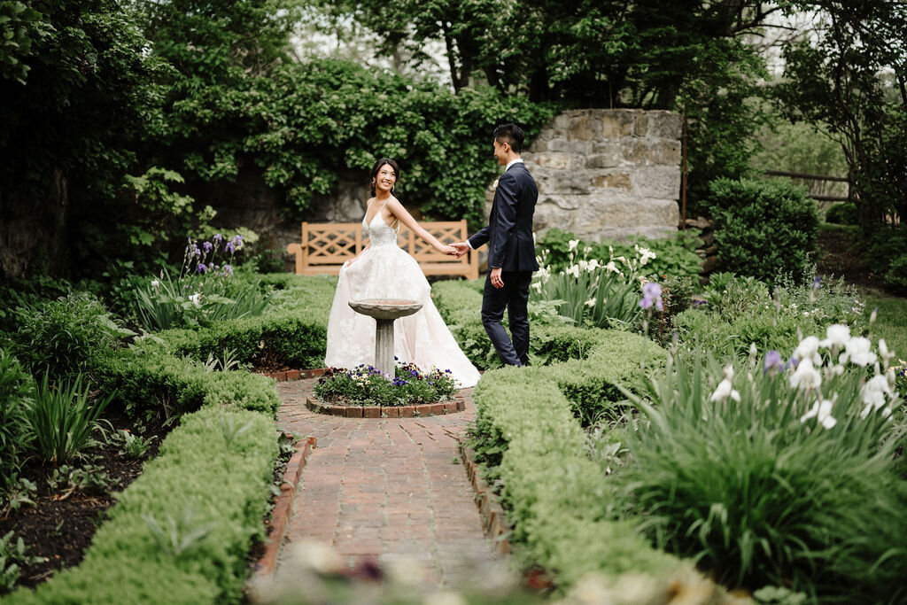 Stunning bride and groom wander through gardens on their wedding day